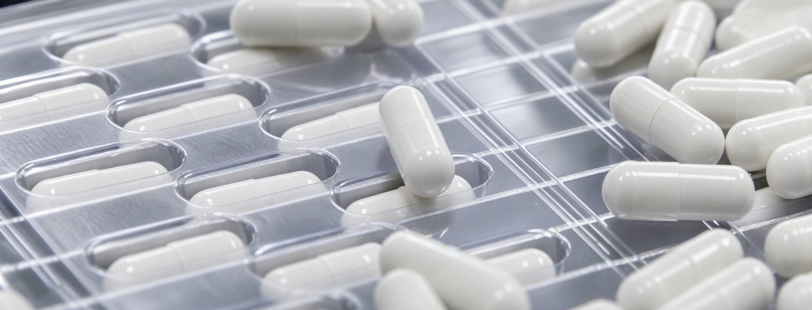 White nutraceutical capsules on a production line